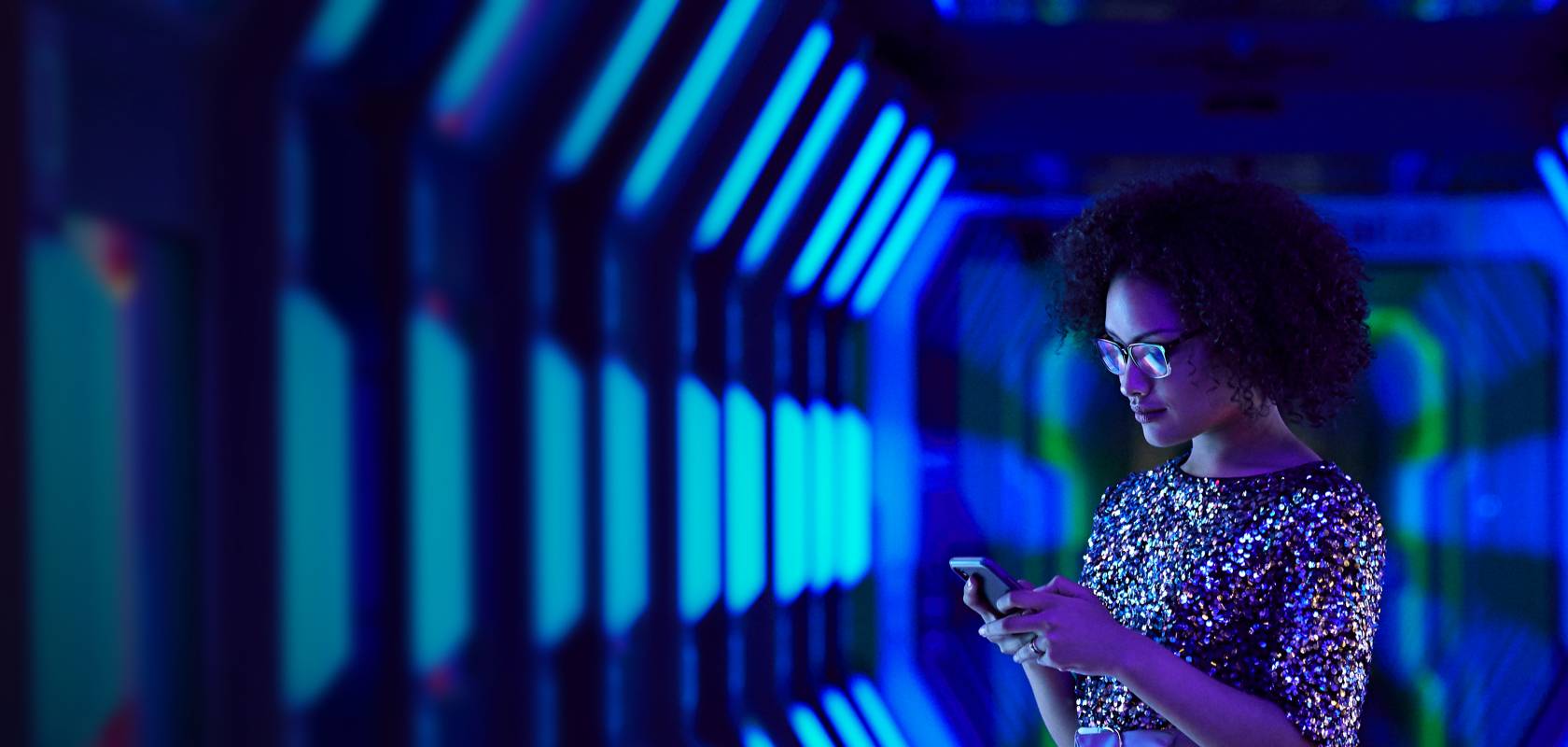 Frau im blauen Tunnel mit Smartphone in der Hand
