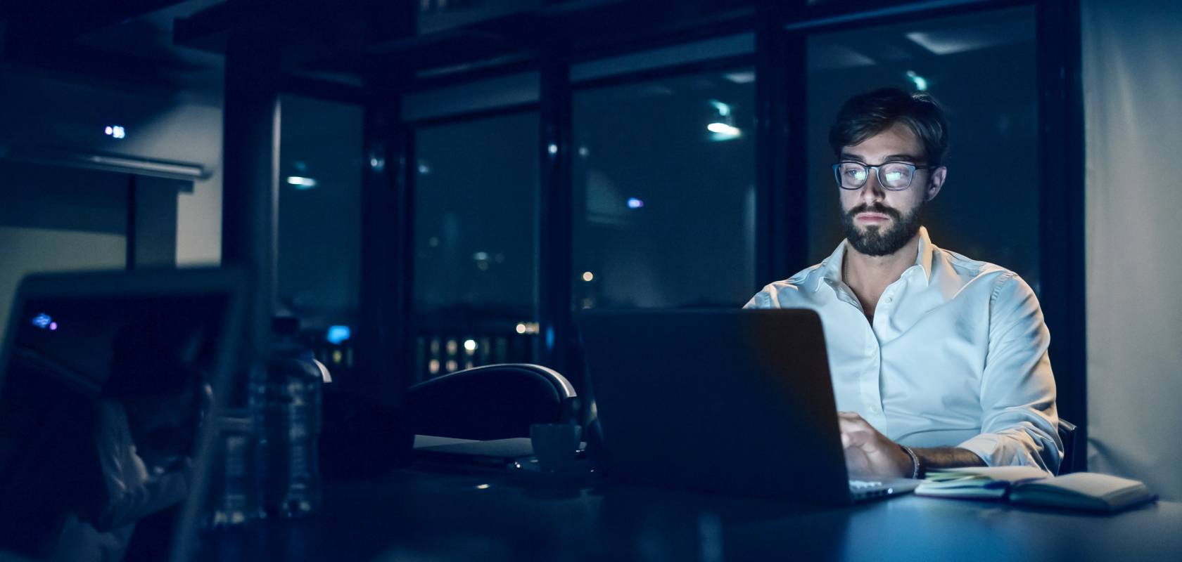 Wissen und Inspiration Webinare Mann sitzt mit einem weißen Hemd vor einem Laptop